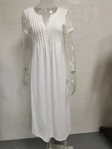 Details view of elegant white long dress with short sleeves, lace trim and front button design.