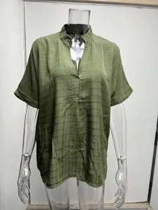 Close up view of women short sleeve V neck loose green plaid shirt fabric detail.