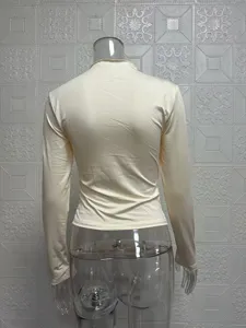 Back view detail of solid color long sleeve slim fit base top with crew neck and subtle ruffle.
