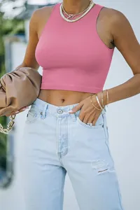 Close-up detail shot of women's summer solid color sleeveless racerback crop tank top in pink.