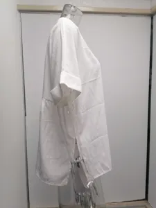 Side view detail of a loose white short-sleeve V-neck shirt, showing side slit and fabric texture.