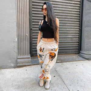 Streetwear fleece-lined sweatpants featuring edgy skull and butterfly graphics for daily style.