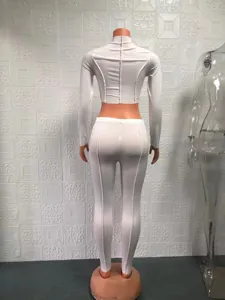 White two-piece crop top and leggings set for women, featuring trendy exposed seam design.