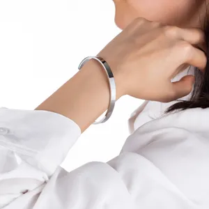 Nahaufnahme eines schicken silbernen Edelstahls C-Manschettenarmbands am Handgelenk.
