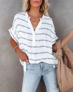 Detail view of women's short sleeve V-neck striped loose summer blouse with chic woven tote bag.