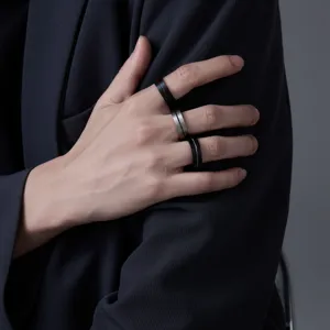 Nahaufnahme minimalistischer schwarzer Titanringe an der Hand, edles kühles Design.