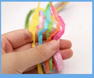 Detaillierte Nahaufnahme von bunten Papierbast-Bändern für handgemachte Geschenkverpackungen.