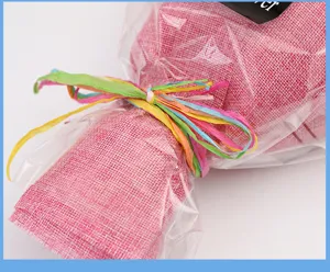 Bunte Bastkordel aus Papier und rosa Netzverpackung für kreatives DIY-Geschenkverpacken.