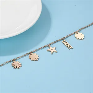 Roségoldfarbenes Edelstahl Charm Armband mit Stern und Kleeblatt Anhängern für Damen.