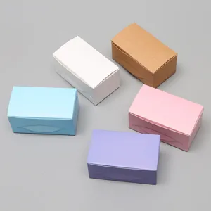 Vue détaillée de petites boîtes de rangement en carton colorées sur surface neutre.
