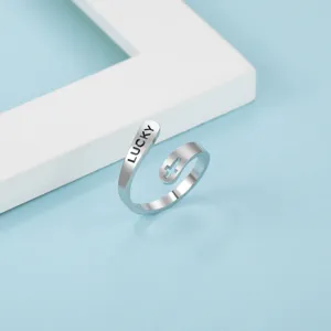 Modischer offener Titanstahl Ring mit LUCKY Gravur und elegantem Kreuz Ausschnitt.