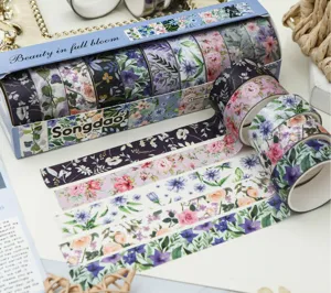 Détail de ruban adhésif washi floral avec divers motifs botaniques et bandes colorées.