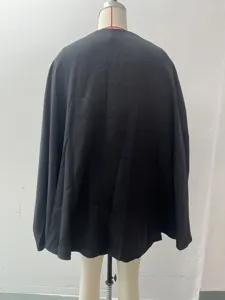 Vista posteriore dell'abito con mantella nera, tessuto liscio e linee di taglio pulite.
