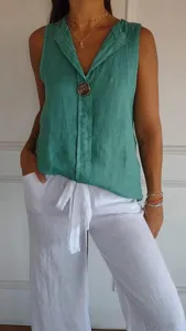 Sleeveless green linen top detail showing V-neck design and decorative front button.