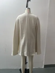 Cappotto mantella da donna in tinta unita vista posteriore esposto su manichino.
