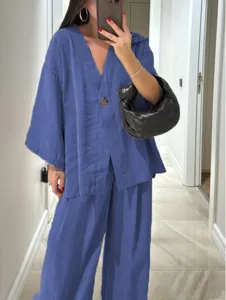 Casual blue linen two-piece outfit detail showing relaxed V-neck top and wide-leg trousers.