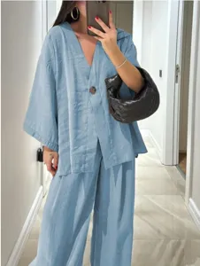 Casual light blue two-piece linen blend outfit featuring a loose V-neck top and wide-leg trousers.