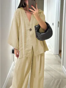 Detail view of the casual loose V-neck top and wide leg pants set in light khaki.