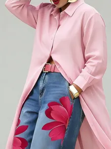 Closeup detail of stylish pink long shirt, matching pink belt and floral print blue jeans.