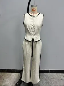 Vista dettagliata del elegante set di gilet senza maniche e pantaloni lunghi in beige con bordo nero.