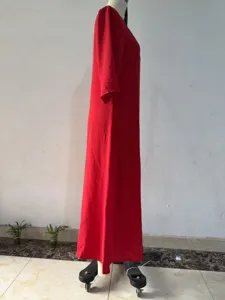 Side detail view of the elegant red maxi dress showing its flowing long silhouette.