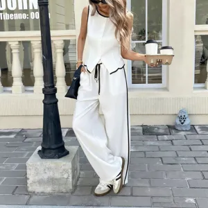 Completo elegante da donna con gilet e pantaloni, outfit bianco casual con dettagli neri.