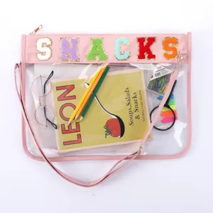 Sac bandoulière étanche transparent en TPU avec détail de lettres en feutre colorées.