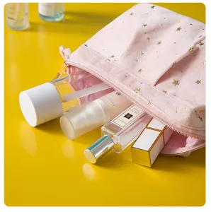 Detailed view of the pink velvet cosmetic bag featuring elegant gold star prints and smooth zipper.