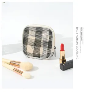 Vista detallada del bolso cosmético de malla portátil con diseño de cuadros y cremallera limpia.