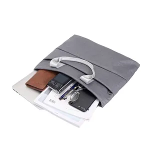 Bolso de mano de lona gris para ordenador portatil con compartimentos multiples.