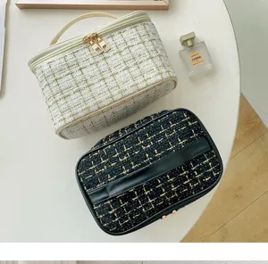 Detail view of stylish tweed cosmetic makeup storage bag with elegant texture and handle.