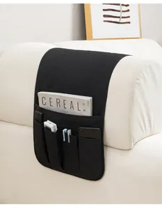 Organizzatore per bracciolo divano nero trapuntato con tasche multiple per telecomando e telefono.