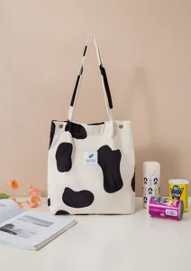 Bolso bandolera informal de pana con estampado de vaca, diseño espacioso y elegante.