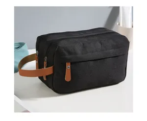 Nahaufnahme einer schwarzen Reise-Kulturtasche aus Canvas mit braunen Ledergriffen.