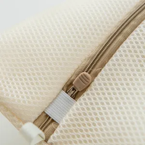 Gros plan sur la fermeture éclair et le tissu du sac à linge en filet durable pour les vêtements.