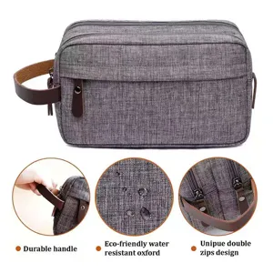 Neceser gris de tela oxford para hombre con tejido impermeable y asa de cuero resistente.