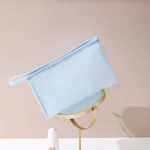 Detalle del neceser azul de malla con asa cómoda para viajes y uso diario en el hogar.