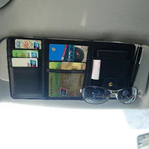 Detalle de organizador de visera de coche con ranuras para tarjetas y soporte de gafas.
