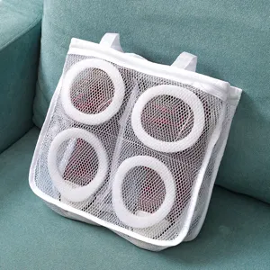 Detail view of white mesh shoe wash bag with hanging straps for laundry drying and protection.