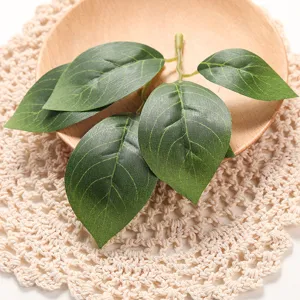 Artificial green leaves branch detail for home decor, wedding props, and photography display.