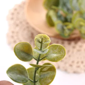 Detalle de tallo de hoja de eucalipto artificial, ideal para arreglos florales y decoración.