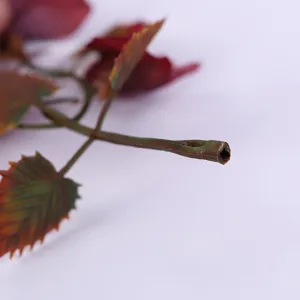 Detailed close-up view of artificial plant stem and colorful leaves for vase arrangement.
