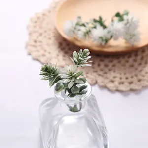 Artificial green plant in glass bottle, perfect for home desktop decor and interior styling.