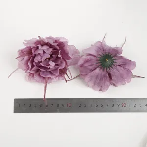Detail view of purple artificial silk peony flower head showing velvet texture and petals.