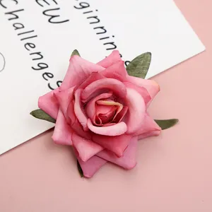 Artificial pink silk rose flower head, detailed view of floral craft for wedding decor DIY.