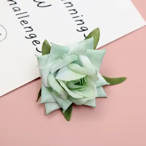 Close-up detail of light green artificial rose flower head with fabric leaves for DIY decor.