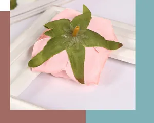 Nahaufnahme des künstlichen rosa Rosenblütenkopfes mit realistischen grünen Kelchblättern.