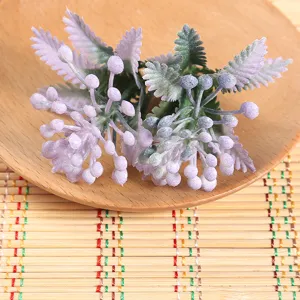 Detailed close-up of artificial purple berries and fern leaves, perfect for home floral decor.