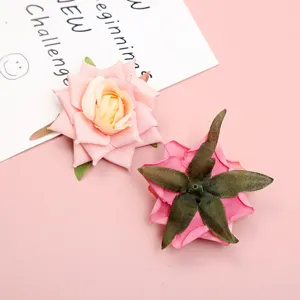 Artificial silk rose flower heads close-up, pink floral decor for DIY crafts and wedding.