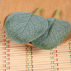 Artificial eucalyptus leaves close up, realistic green fabric plant detail, floral arrangement prop